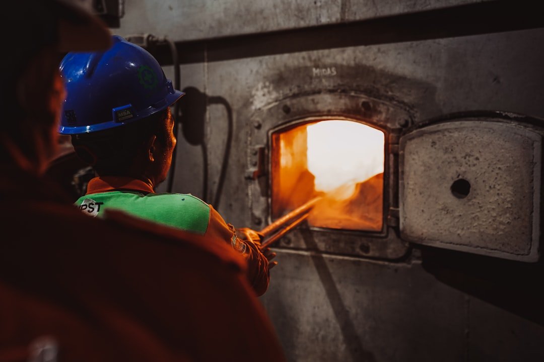 a-man-in-a-hard-hat-working-on-a-furnace-icpcsysvauc